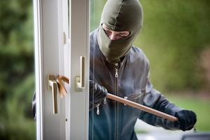 masked burglar breakig into a home